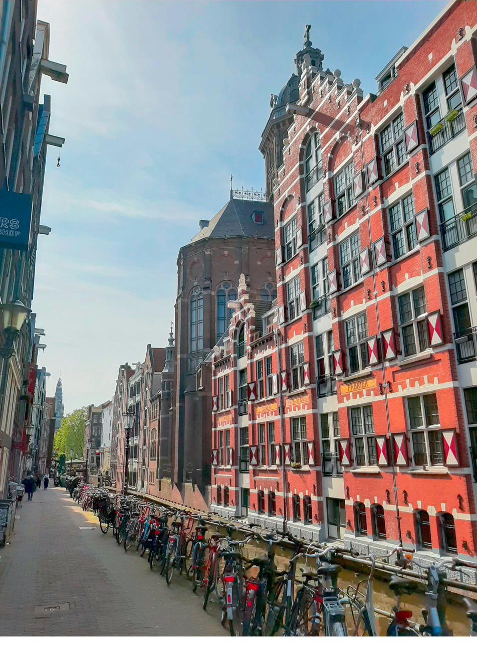 Bikes parked along an Amsterdam canal street with historic buildings